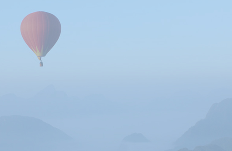 Roter heißluftballon über Gebirge